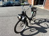 un vélo garé dans la rue devant un immeuble