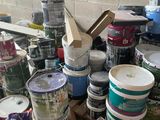 many cans of paint and cans of paint sitting on a table