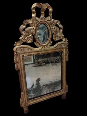 un miroir posé par terre devant un fond noir