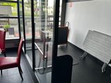 a red chair sitting in front of a glass door