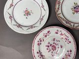 three plates with floral designs on them are sitting on a table