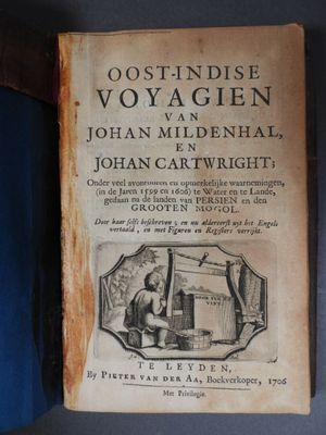 un vieux livre posé sur une table, à côté d'un livre bleu