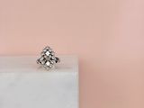 an image of a diamond ring sitting on top of a marble block