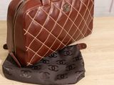 a brown purse sitting on top of a bag on a table