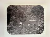 a black and white photo of a man and a dog in the woods