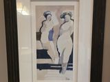 tableau représentant trois femmes, dans un cadre noir, accroché au mur