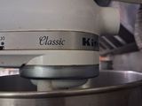 a white mixer with a white bowl on it in a kitchen
