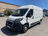 Une camionnette blanche est garée sur un parking près d'un immeuble.