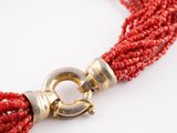an image of a close up of a red beaded necklace on a white background