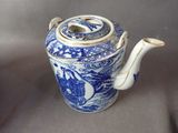 a blue and white teapot with a lid on a table