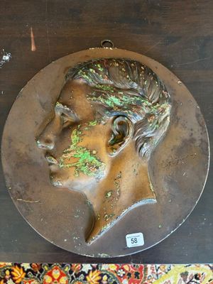 une tête d'homme en bronze posée sur une table en bois