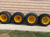 four large tires are lined up against a wall in front of a house