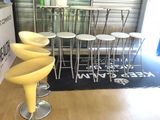 three yellow stools sitting in front of a counter