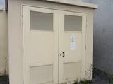 deux portes situées sur le côté d'un bâtiment sur lequel est accrochée une enseigne