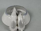 two birds that are sitting on top of a bowl