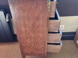 a tall wooden cabinet with three drawers in a room