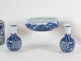 plusieurs vases bleus et blancs et un bol posés sur une surface blanche