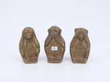 trois figurines en bronze représentant trois singes sur fond blanc