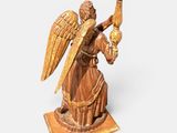a statue of an angel holding a candle in his hand