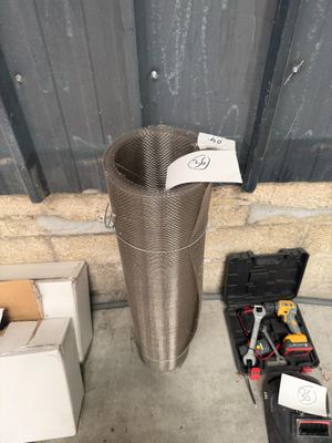 une poubelle en métal posée à côté d'une caisse à outils