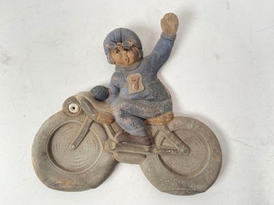 a small figurine of a man riding a bike