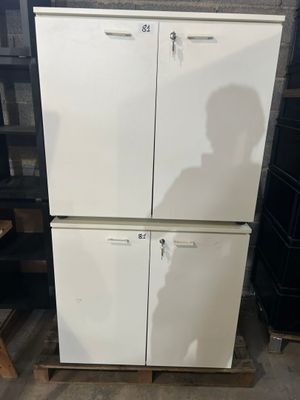 un réfrigérateur blanc posé sur une palette dans un entrepôt