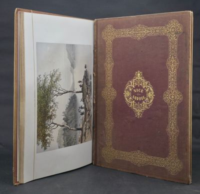 an open book with a picture of a mountain scene on it