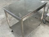 table en acier inoxydable équipée de roulettes, dans un entrepôt