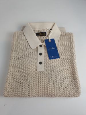un gros plan sur un pull blanc muni d'une étiquette bleue