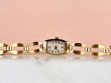l'image d'une montre-bracelet en or entourée d'une chaîne