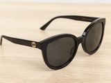 a pair of black sunglasses sitting on top of a wooden table