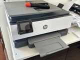 a printer sitting on top of a desk next to a cabinet