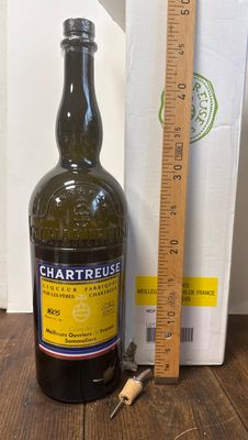une bouteille de vin posée sur une table à côté d'une règle