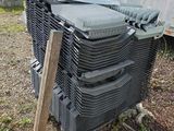 une pile de chaises en plastique empilées les unes sur les autres devant une caravane
