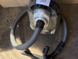 a vacuum that is sitting on the floor next to a wall