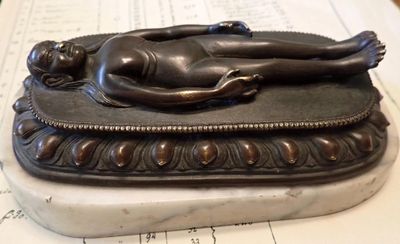 a statue of a woman laying on top of a book