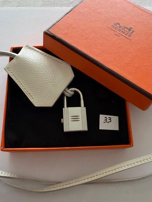 an orange and white gift box with a keychain and a key chain