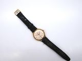 a close up of a watch on a white surface with a black strap