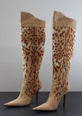 pair of women ' s leopard print boots on a black table
