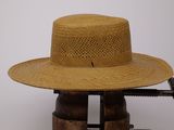 un chapeau de paille posé sur un support en bois