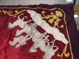 a red pillow with a picture of a horse and rider on it