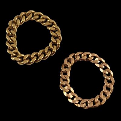 two gold bracelets on a black background
