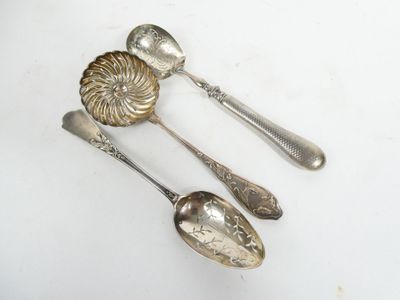 three spoons and two spoons sitting on a table