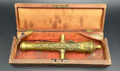 an old brass pipe in a wooden box on a table