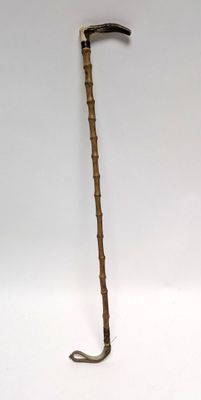 un long bâton en bois muni d'un long manche, sur fond blanc