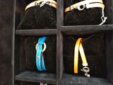 four different colored bracelets in a black case