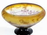un bol jaune avec une inscription, posé sur un socle noir