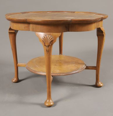 une table ancienne en bois, avec un plateau circulaire et deux pieds