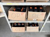 several boxes of black bottles on a shelf in a warehouse