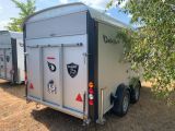 two trailers that are parked next to each other in the grass